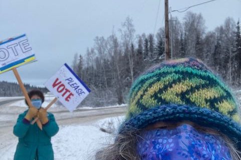 Winter image with women waving voting signs