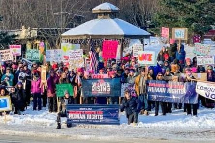 Image of people gathered with signs.